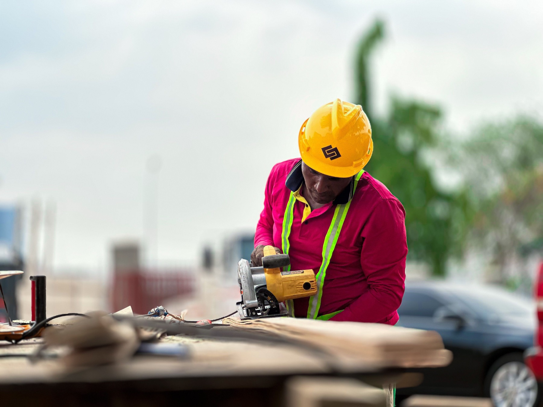 A construction professional cutting wood with a circular saw