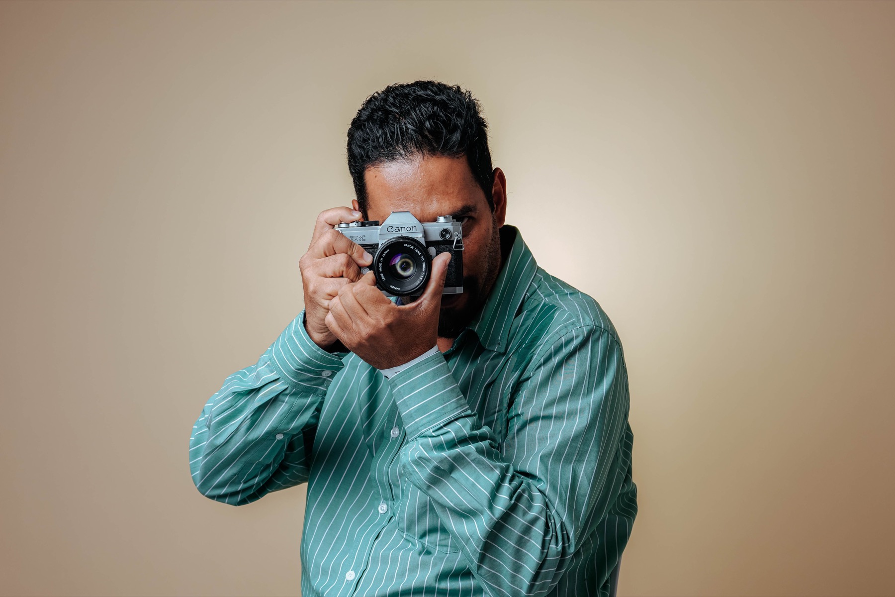 A professional photographer looking through his camera